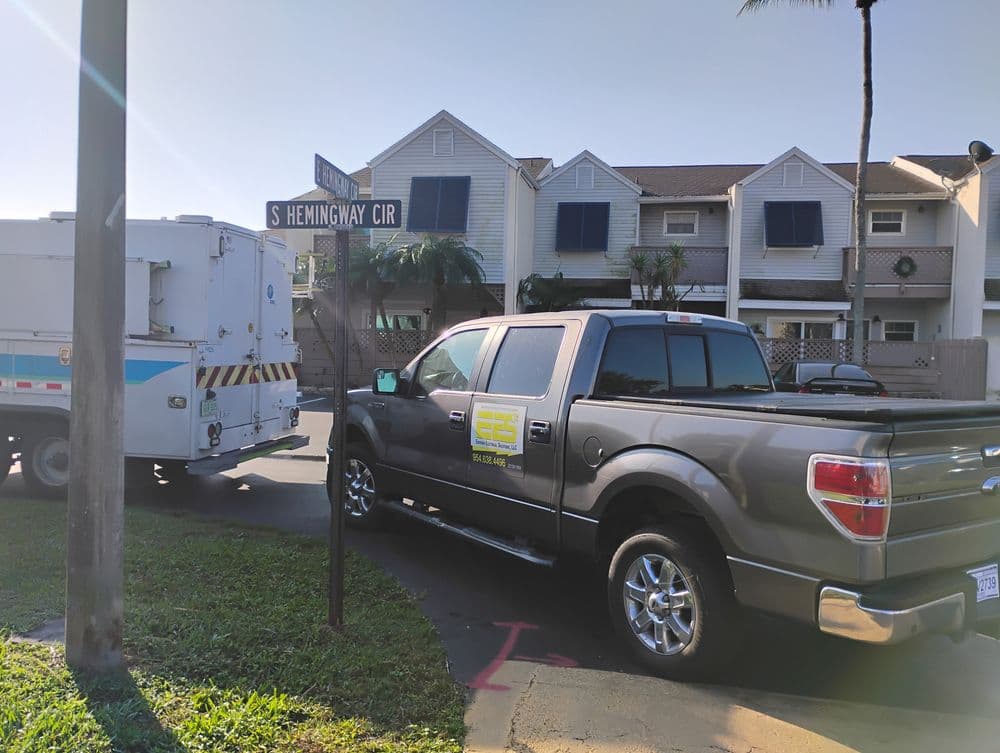 Gray pickup truck parked near street sign for S Hemingway Cir and service vehicle in background.